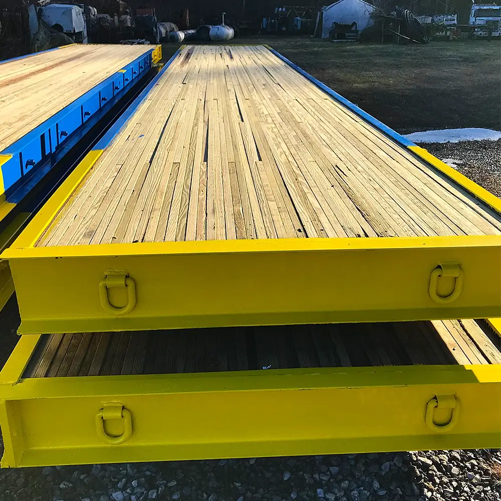 End view of stacked bridge panels showing timber laminations and steel channel frame